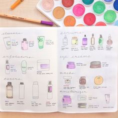 an open notebook with watercolors and bottles on it