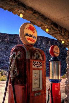 an old fashioned gas pump sitting in front of a mountain side building with the word mobhl's special written on it