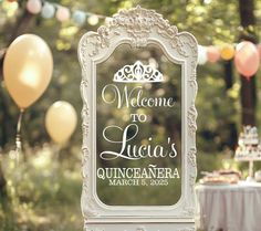 a welcome sign is displayed in front of balloons and tables with desserts on them