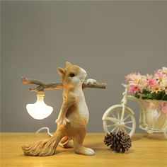 a small squirrel figurine next to a light bulb