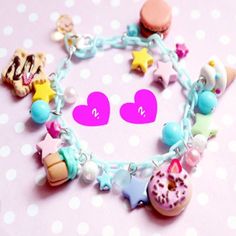 a close up of a bracelet with charms and doughnuts on it, next to a polka dot background