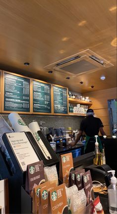 starbucks coffee shop with menus on the wall and people working behind the counter in the background