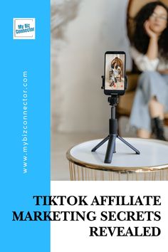 a woman taking a photo with her cell phone while sitting on a chair in front of a table