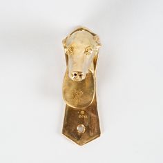 a gold brooch with a dog's head on it