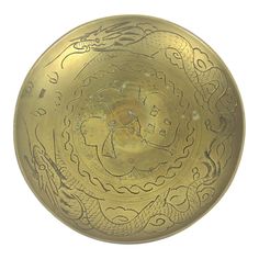 an antique brass plate with dragon designs on it