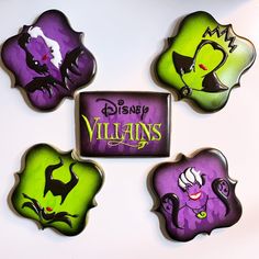 four decorated cookies in the shape of disney villain's faces