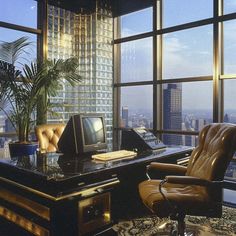 an office with a desk, chair and computer in front of large windows overlooking the city