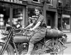 an old black and white photo of a man on a motorcycle in front of a store