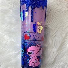 a purple and blue tumbler with an image of a pink elephant on it's side