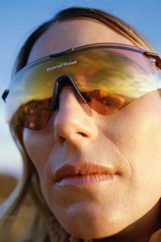 a woman wearing sunglasses with the sun reflecting her face