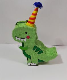 a green dinosaur with a party hat on it's head