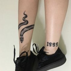 a woman's leg with a snake tattoo on it and the word feed written in black ink