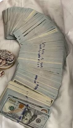 a pile of money sitting on top of a bed