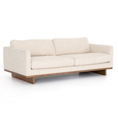 a white couch sitting on top of a wooden frame