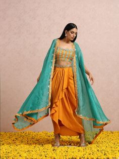 This fusion set features a rust embellished top and dhoti with an embroidered belt. To add a modern twist,it has a teal embroidered silk organza cape. Color: Pink Fabric: Silk and Organza Note: The product will be shipped within 30-35 days of order placed Wash care - Dry Clean Only. Do not use heavy Iron Dhoti Dresses For Women, Teal Crop Top, Royal Blue Lehenga, Dhoti Skirt, Ruffle Lehenga, Silk Organza Fabric, Organza Cape, Silk Cape, Raw Silk Lehenga