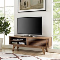 a flat screen tv sitting on top of a wooden entertainment center in a living room