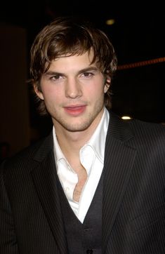 a young man wearing a suit and white shirt