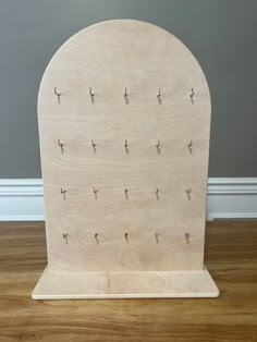 a wooden stand with several pegs on the top and two holes in the middle