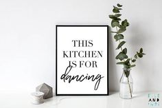 this kitchen is for dancing print in black and white on a shelf next to a plant