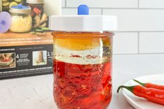 a jar filled with food sitting on top of a table next to a white plate