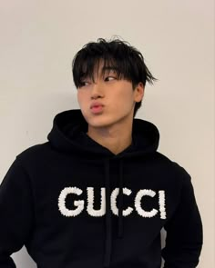 a young man wearing a black hoodie with the word gucci printed on it