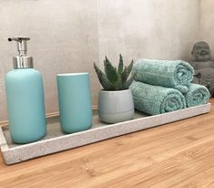 towels, soap dispenser and cactus on shelf in bathroom