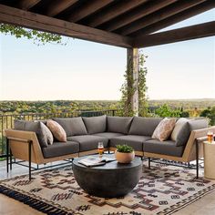 an outdoor living area with couches, tables and potted plants