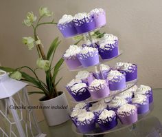 cupcakes are stacked on top of each other in purple and white frosting