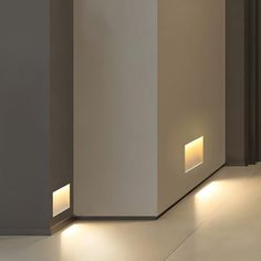 two lights are on the side of a wall in front of a door and floor