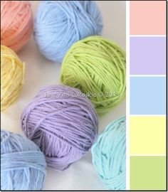 several balls of yarn sitting next to each other on a white surface with color swatches