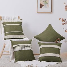 two green pillows sitting on top of a bed next to a white blanket and wooden chair