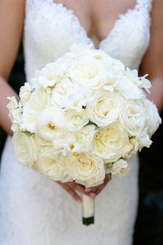 a bride holding a bouquet of white flowers