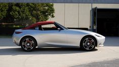 a silver sports car parked in front of a building