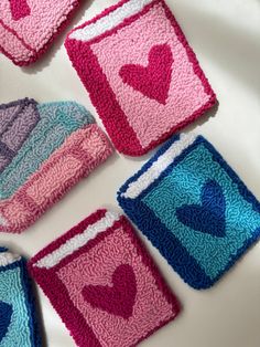 crocheted coasters with hearts on them sitting on a white tablecloth covered surface