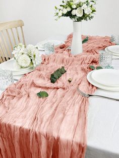 the table is set with white and pink flowers