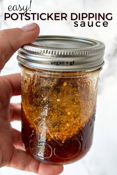 a hand holding a mason jar filled with vegan and gf