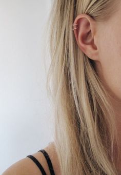 a close up of a person wearing ear clips