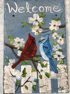 a painting of two birds sitting on a tree branch with the words welcome painted on it