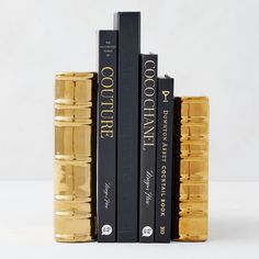 two books are stacked on top of each other in front of white background and black bookcases