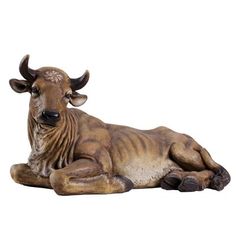 a statue of a cow laying down on the ground