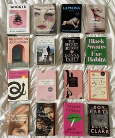 there are many books that are on the white bed spread out in this picture together