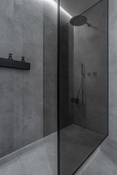 a bathroom with a walk in shower next to a wall mounted faucet and hand held shower head