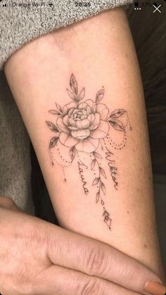 a woman's arm with a rose tattoo on it, and an arrow in the middle