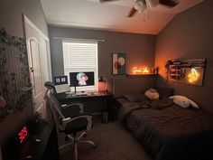 a bed room with a neatly made bed next to a desk and computer on top of it