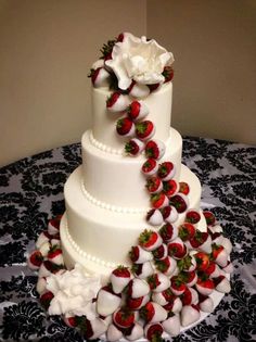 a wedding cake with strawberries and roses on it