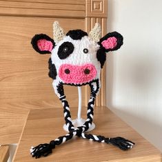 a knitted cow hat sitting on top of a wooden table