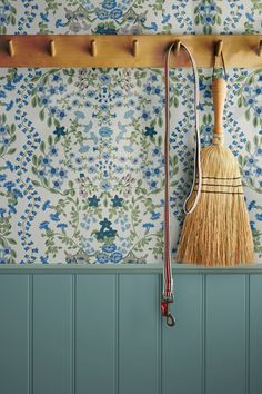 a broom is hanging on the wall next to some pictures