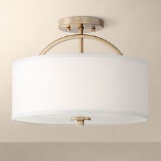 a light fixture with a white shade hanging from the ceiling