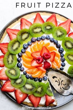 a fruit pizza with kiwis, strawberries and blueberries