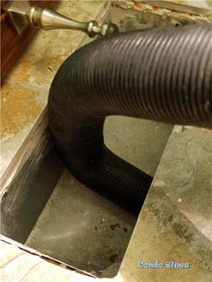 a black blow dryer sitting on top of a floor next to a tile floor